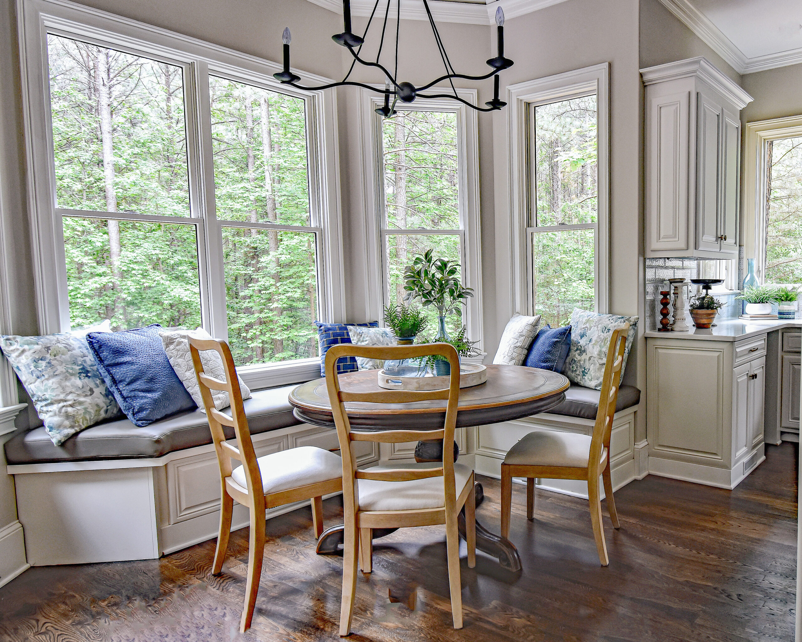 A beautiful breakfast nook with a wall of windows and a banquette seating