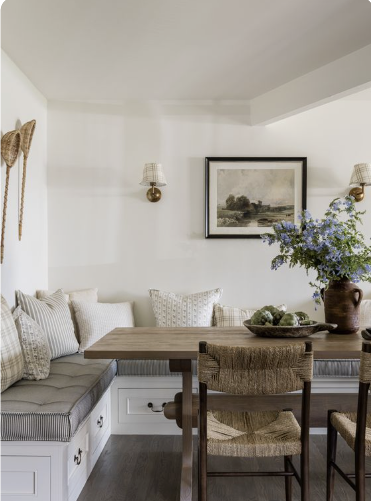 Cottage style breakfast nook with sconces and a banquette bench for seating 