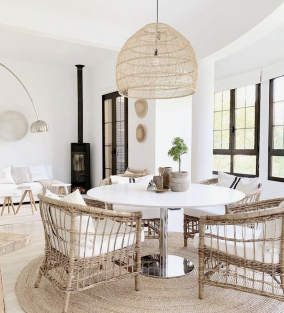 A light and airy breakfast nook with an oversized chandelier and wicker chairs provide a casual feel to this breakfast nook.