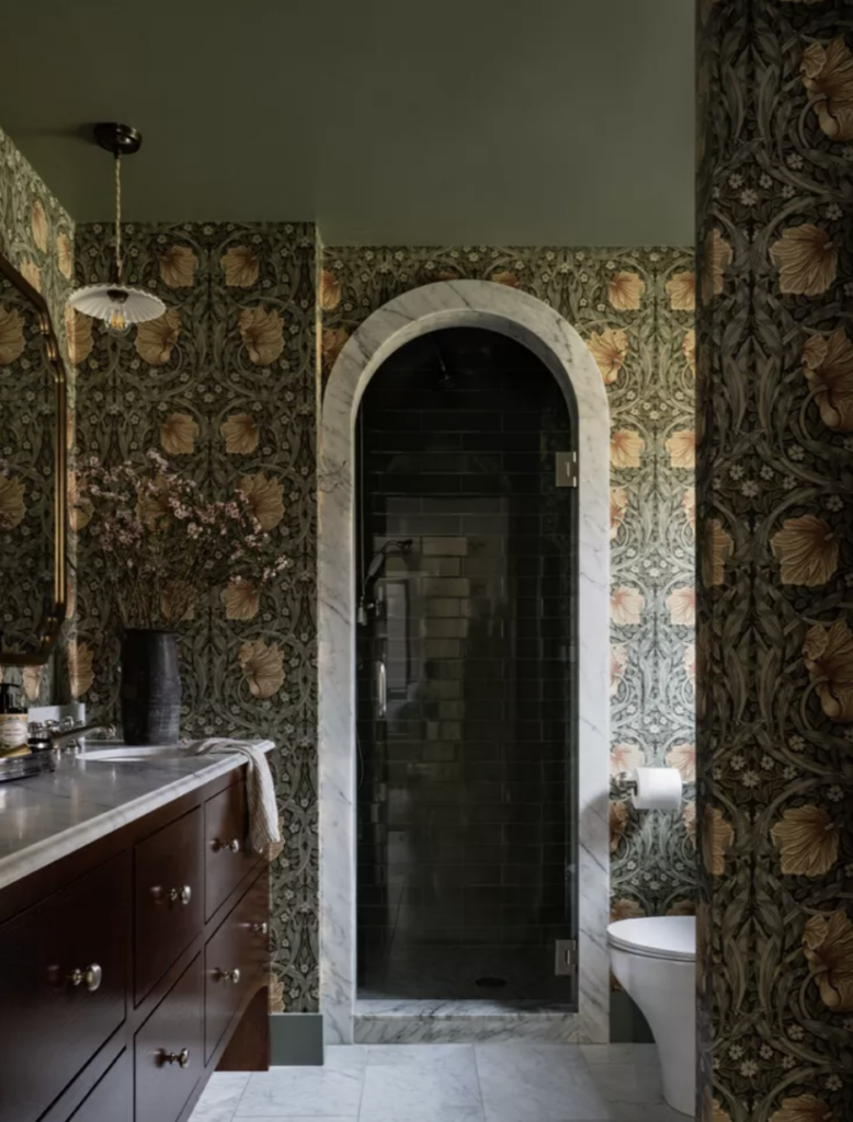 A bathroom with a vintage inspired feel uses Roycroft Bronze Green to highlight the colors in this wallpaper 