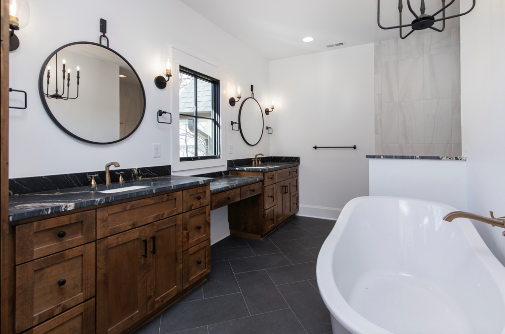 A master Bathroom with black tile, walnut wood tones and mixed metals fills this custom bathroom with personality. Sutton Place Custom Design and Build Firm