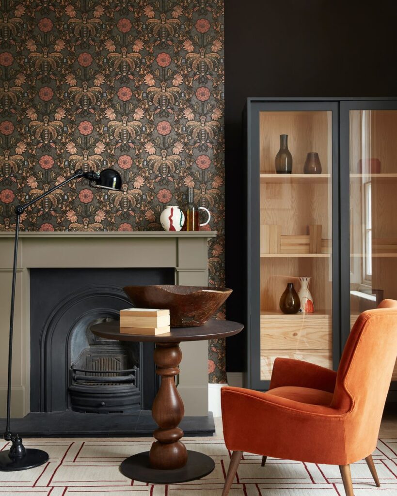 An elegant living room with an accent wall featuring a vintage wallpaper design to highlight fireplace and shelving Denver custom home design and remodel