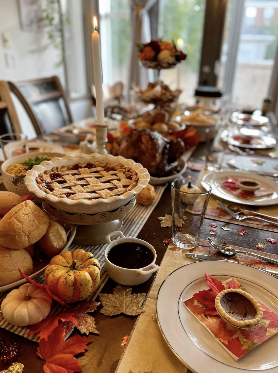 A kitchen island with warming trays holding Thanksgiving dishes, labeled with small chalkboard signs.